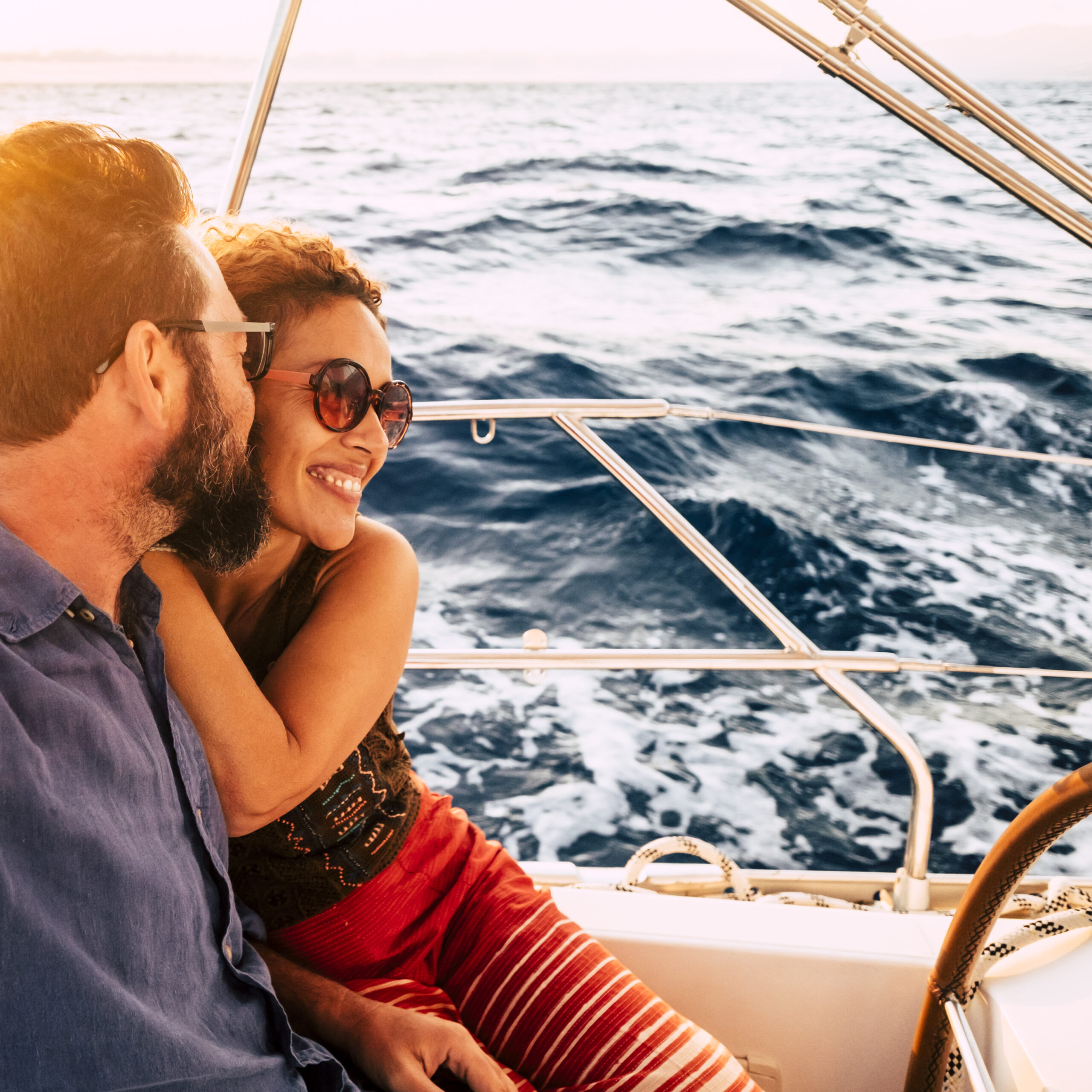 Couple in happiness enjoy a sail tour in yacht - love and romantic lifestyle relationship with adult people in summer holiday travel vacation - ocean and blue water in background
